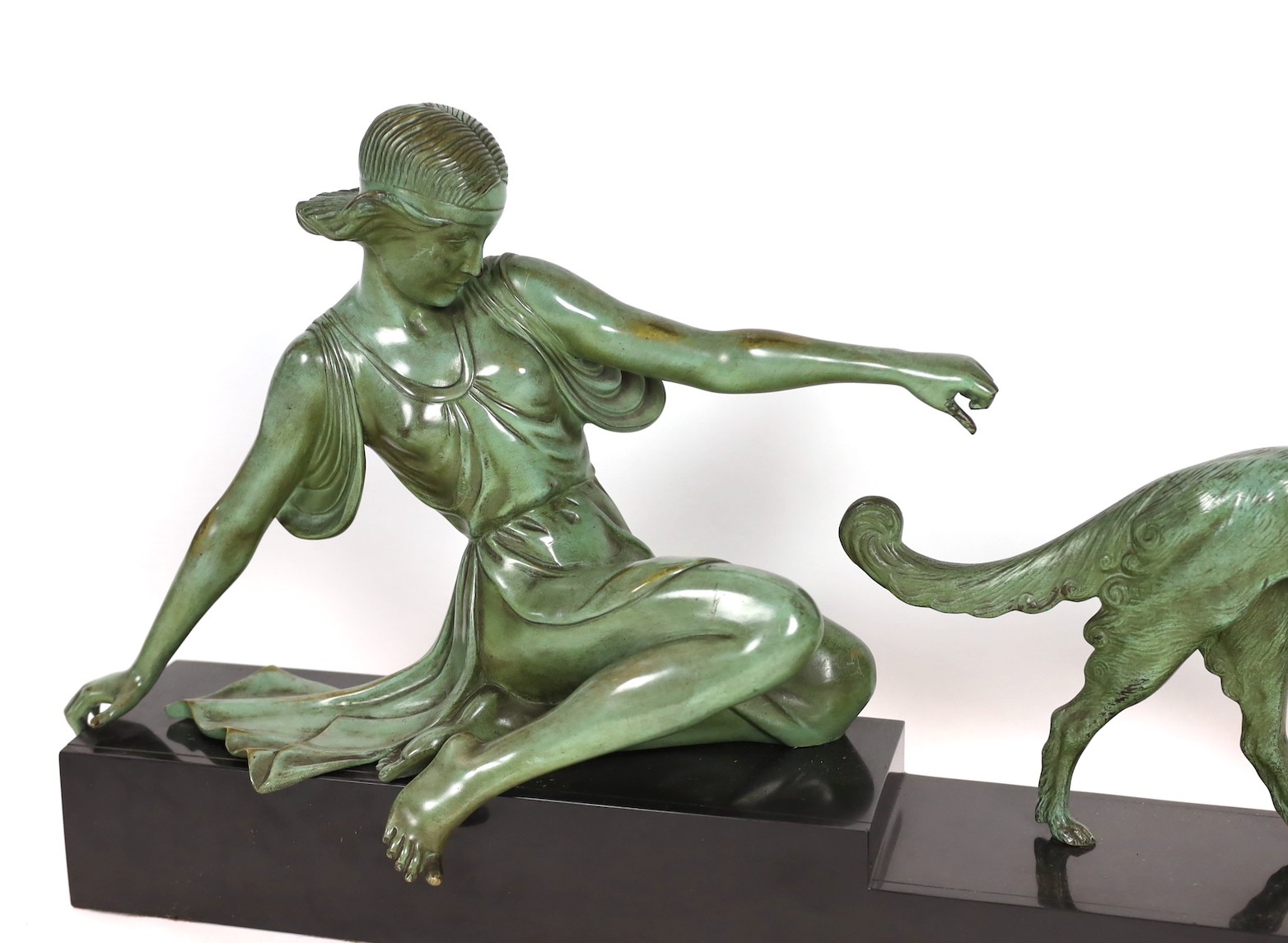 Armand Godard. A French Art Deco patinated bronze and black marble group of a classical woman and borzoi, 80cm wide, 37cm high